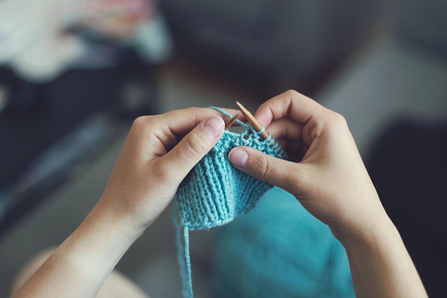a person knitting with light blue yarn